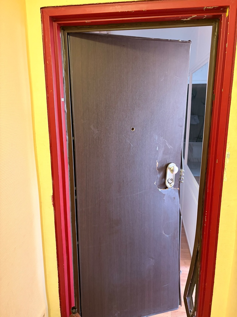 Porte palière fracturée avec placage arraché autour de la serrure après cambriolage