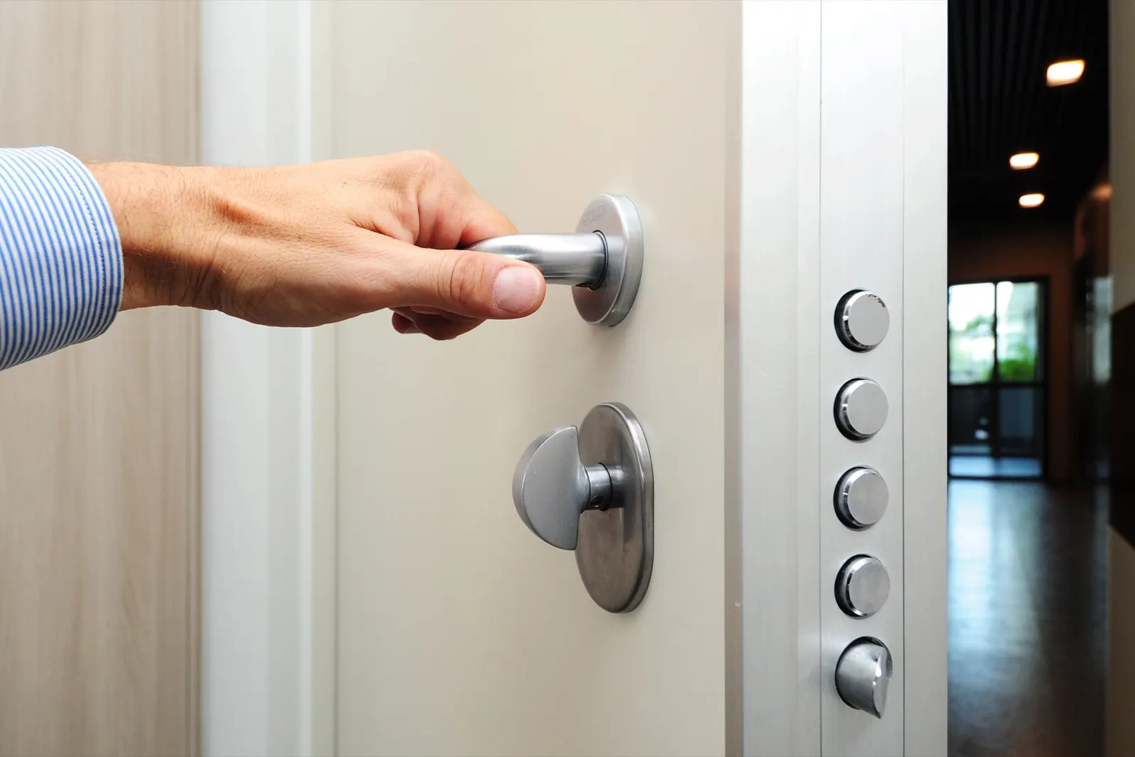 Main sur la poignée d’une porte de sécurité à serrure multipoints